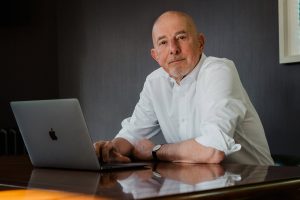 Ewan Kirk, sitting at a laptop.