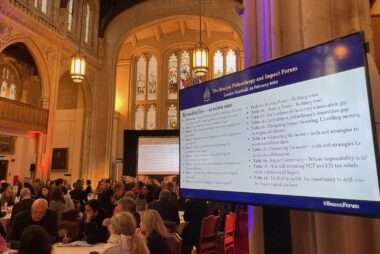 An image of participants at the Beacon Forum sitting talking at tables in the Guildhall in London